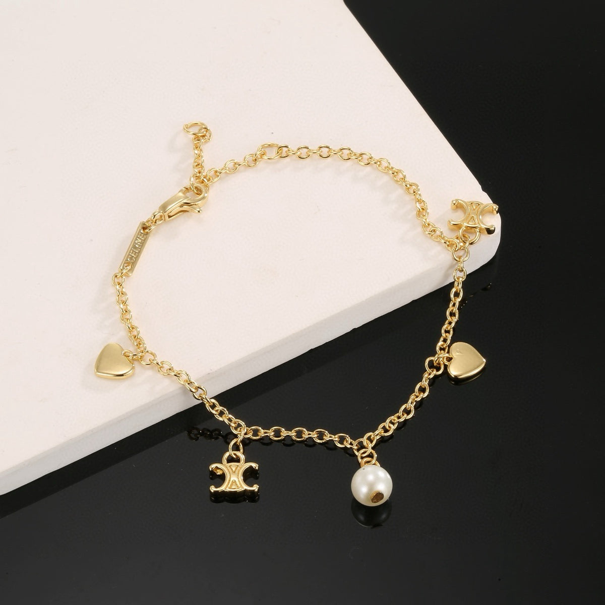 Triomphe-Inspired Emblem Bracelet in Gold-Tone – Red close-up view